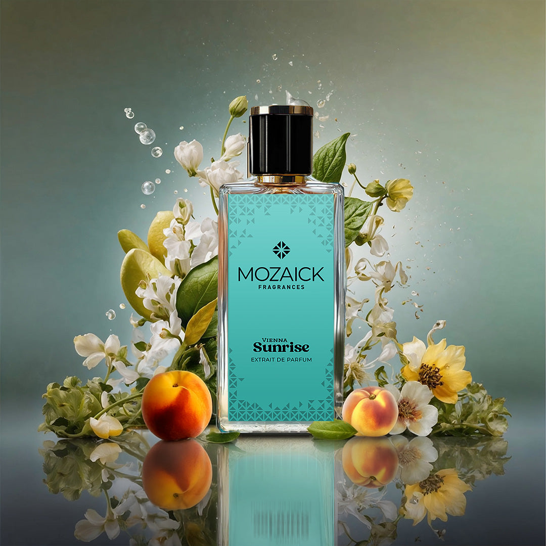 VIENNA SUNRISE Extrait de Parfum 50 ml by MOZAICK – bottle with apricots and pale flowers on a reflective surface